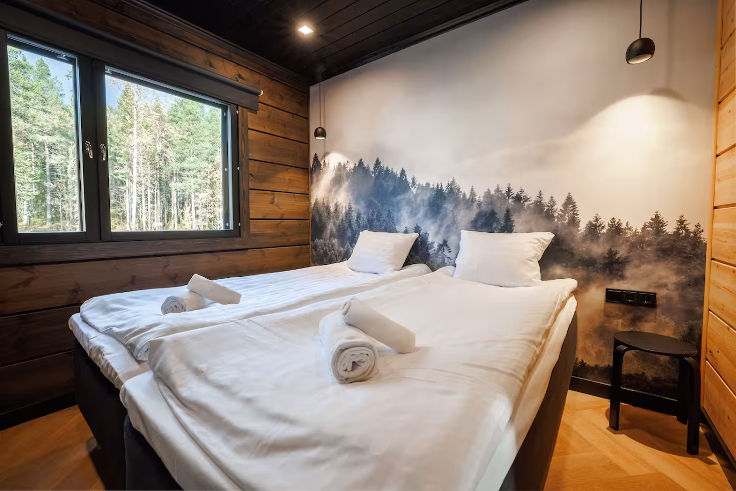 Twin beds against a misty forest wall mural, window onto the pines