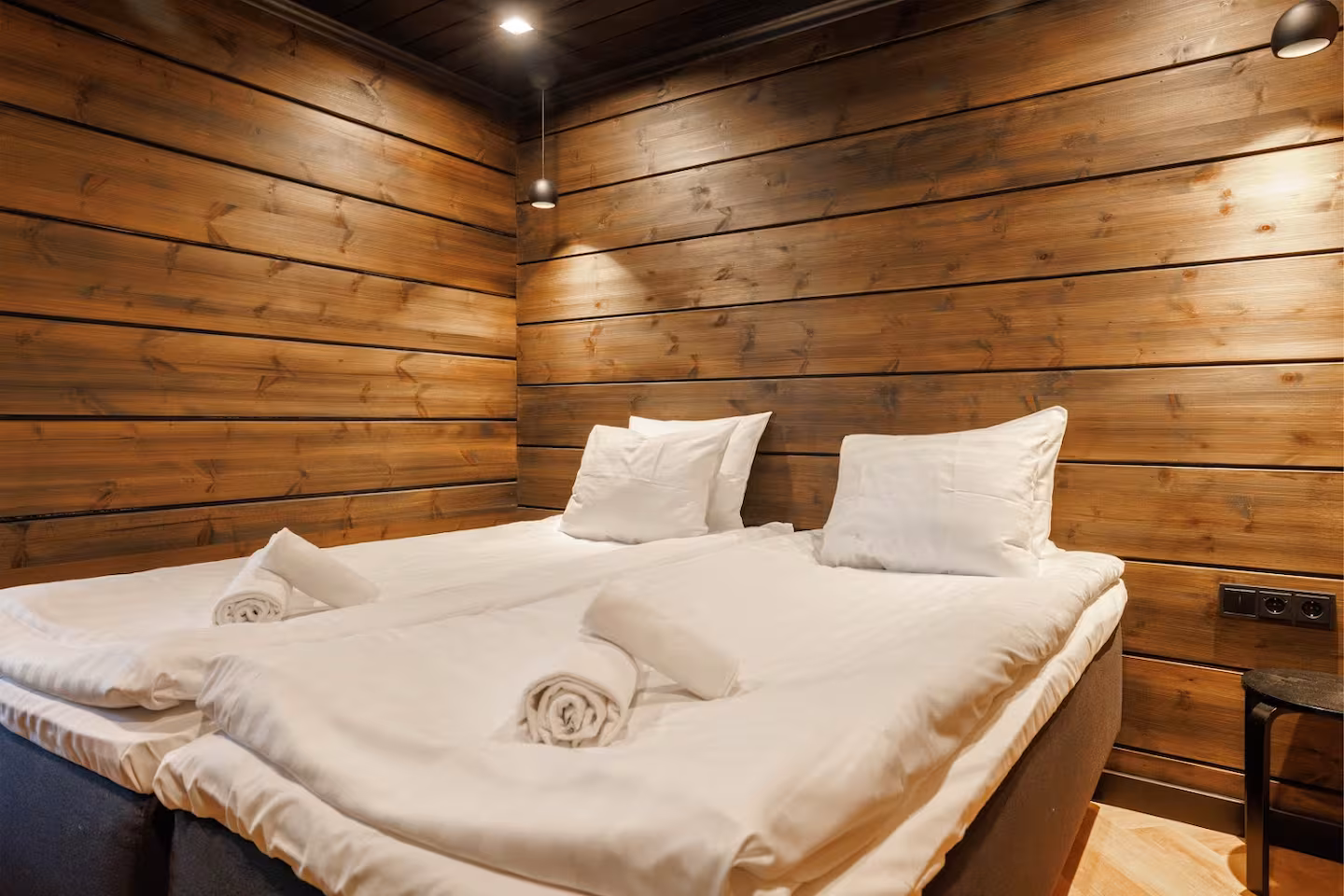 Quiet bedroom with soft pendant lighting and honey-toned timber walls