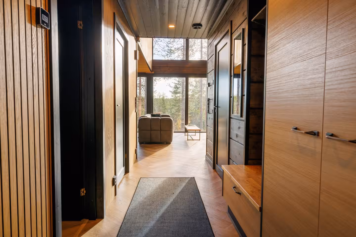 Timber-lined hallway with built-in wardrobes leading towards the bright living room